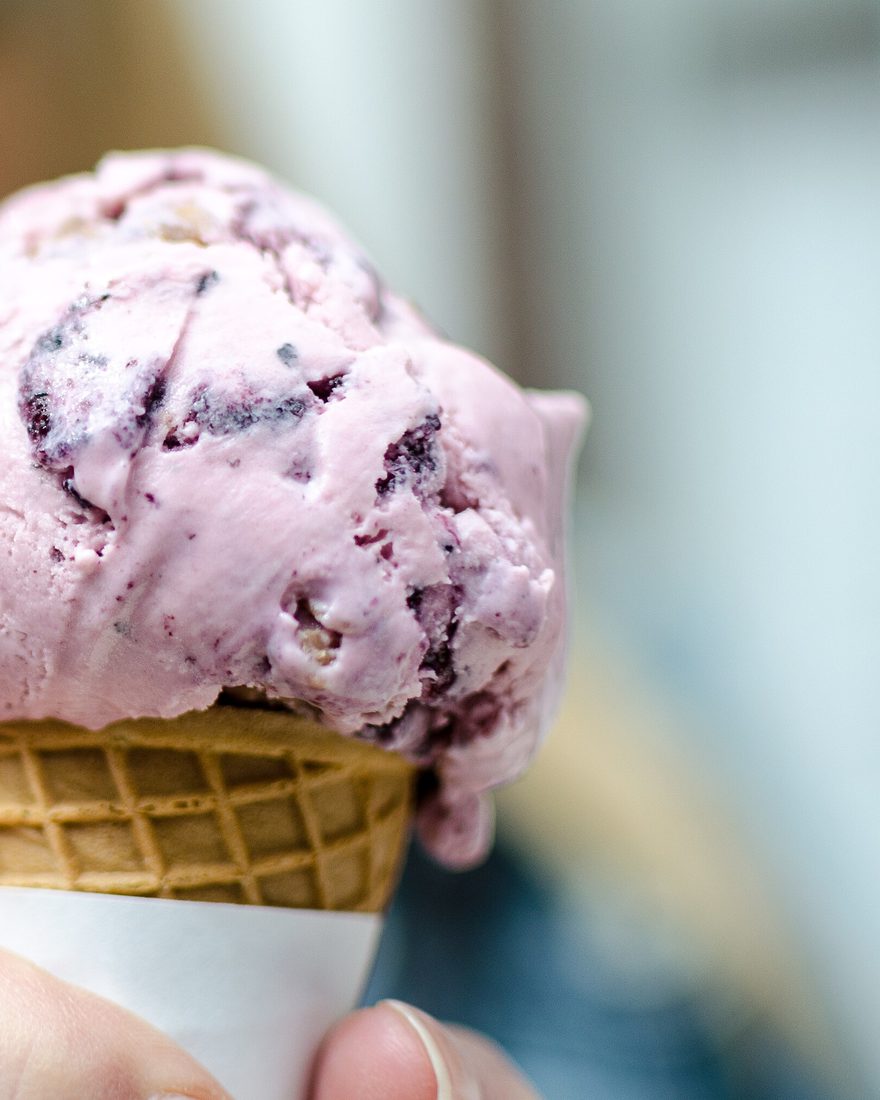 A cone of blueberry ice cream held up to the camera